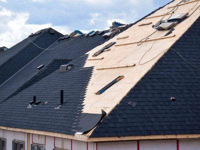 Closeup installation of black roof shingles on new residential home